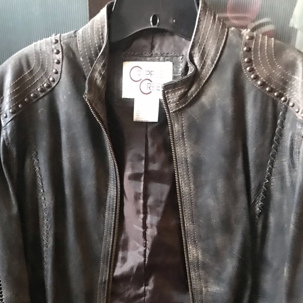 Distressed leather jacket with metal accents